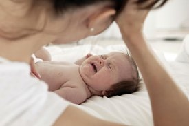 Mother sitting with crying infant with colic